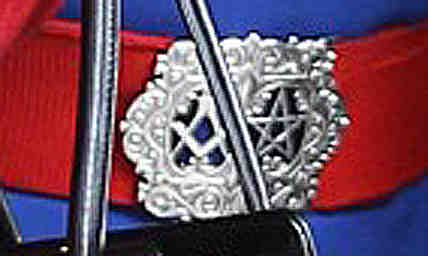The Queen's nurse is wearing a belt buckle bearing Masonic symbols